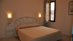 Residence San Teodoro 1. Camera da letto appartamento bilocale